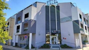 En moderne hotelbygning med et tydeligt skilt, hvor der står 'HOTEL' øverst.