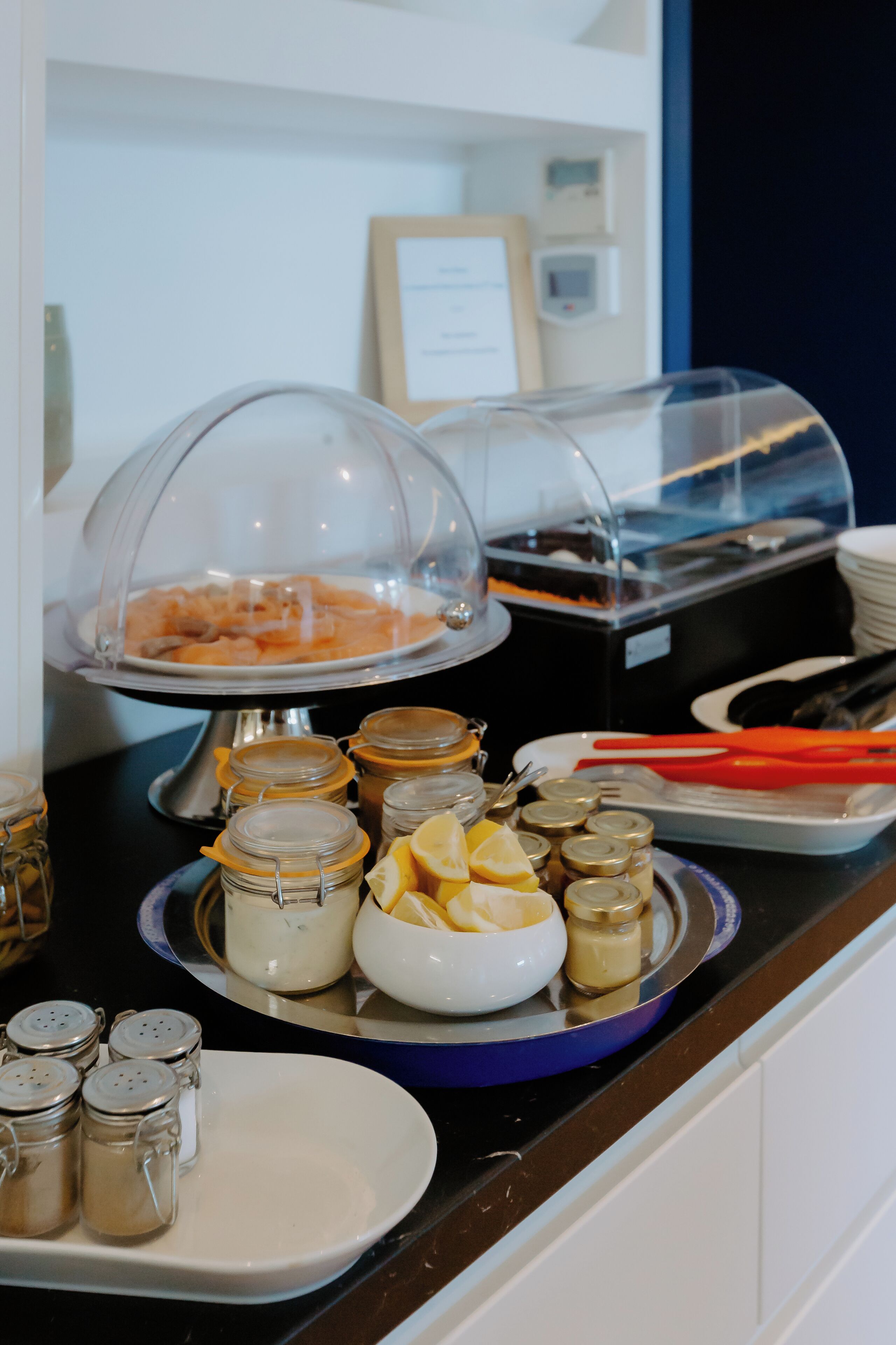 A buffet setup with a variety of food items and condiments.