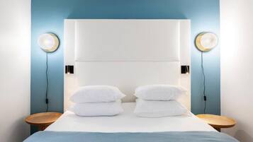 Een moderne hotelkamer met een groot bed, twee nachtkastjes en een royaal hoofdeinde.