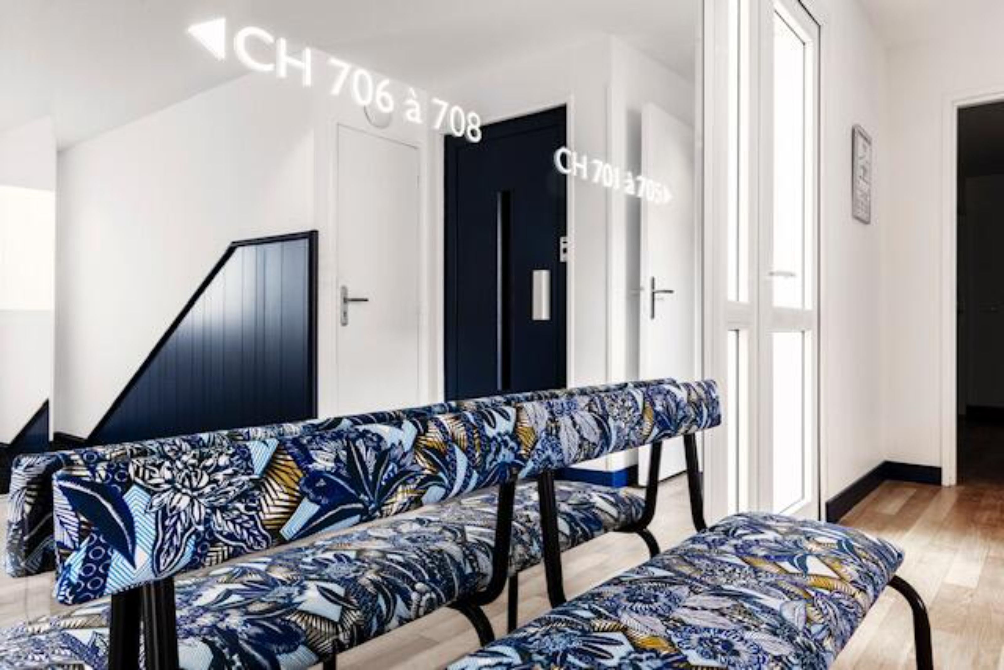 Un hall d’hôtel moderne avec un banc et un escalier.