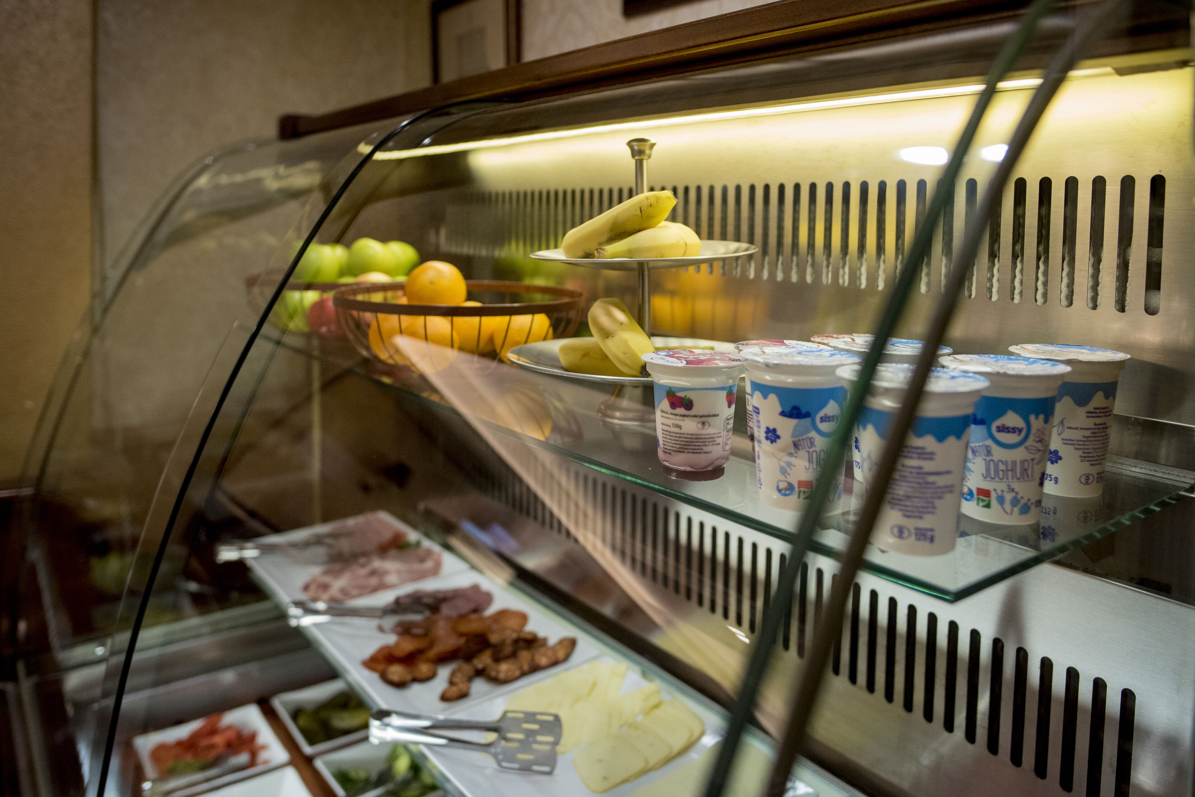 A buffet with various food items including fruits, yogurt, and meats.
