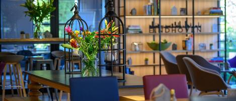 A modern interior with a wooden table, chairs, and a bookshelf with decorative items.
