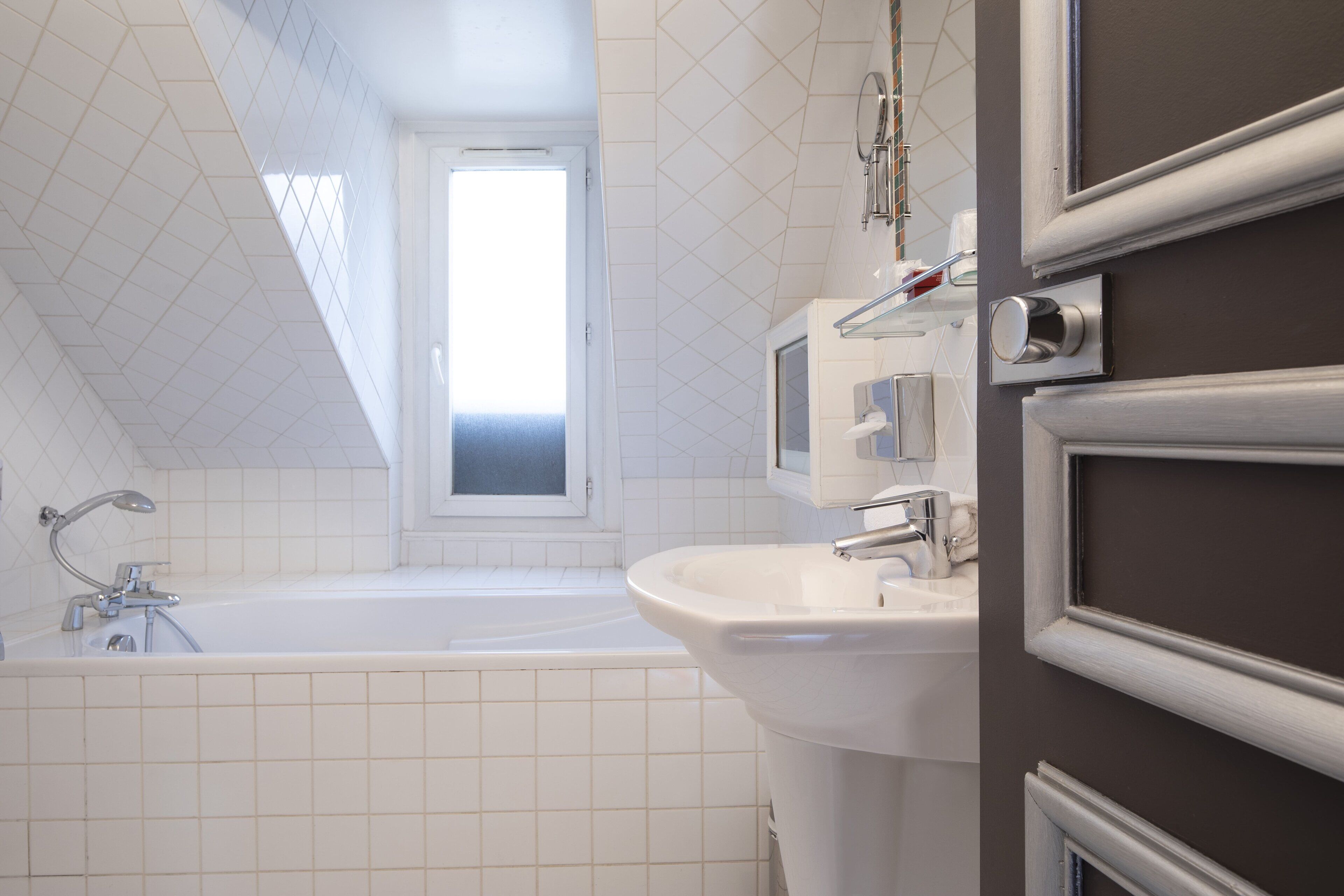 Une salle de bain moderne avec une baignoire, un lavabo et une fenêtre.