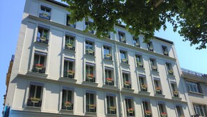 Un hôtel à plusieurs étages doté de balcons ornés de jardinières fleuries.
