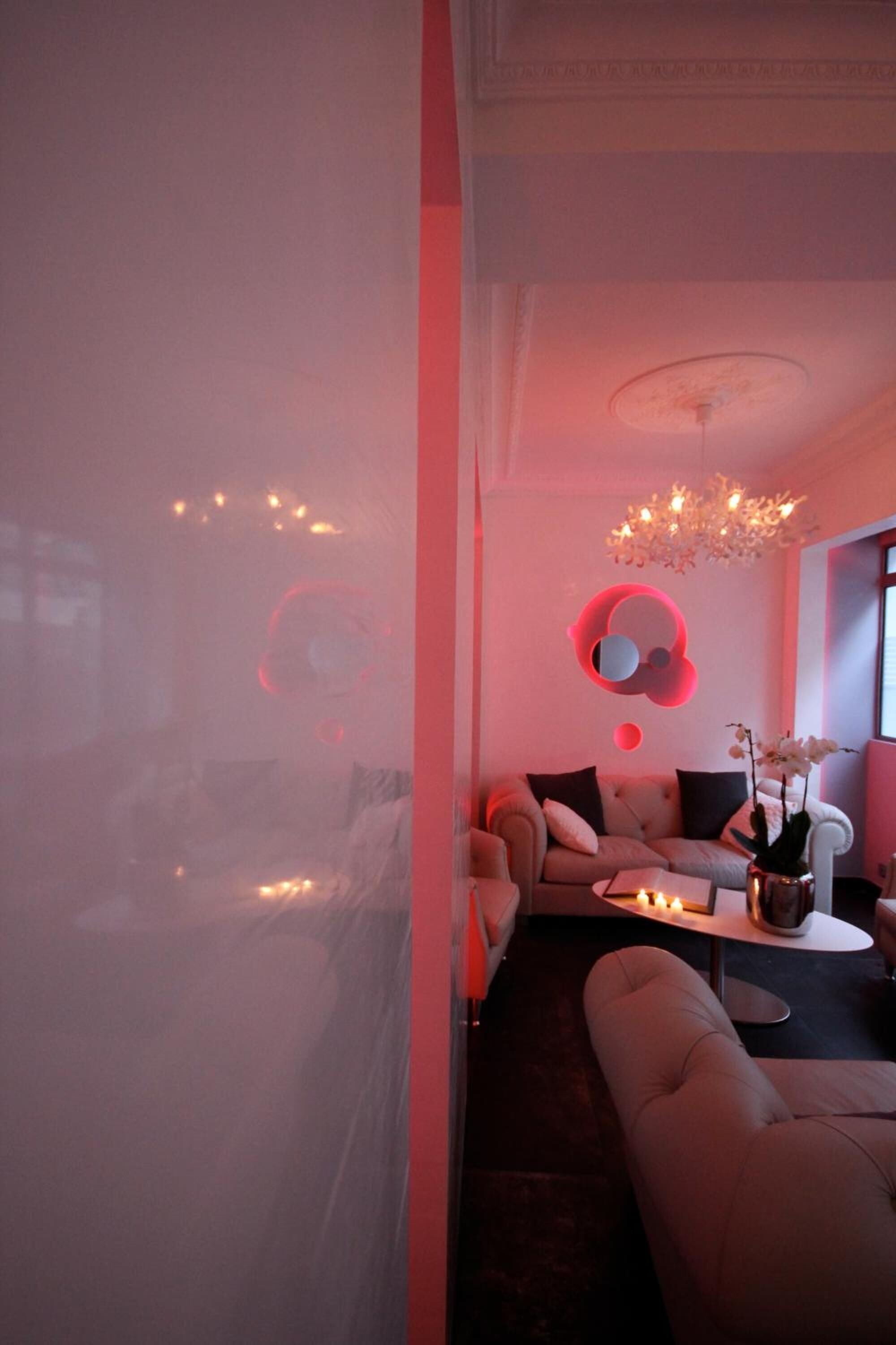 A modern living room with a sofa, a coffee table, and a decorative wall piece.