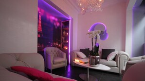 Un salon moderne comprenant un canapé, des fauteuils, une table basse et un vase décoratif avec des fleurs.