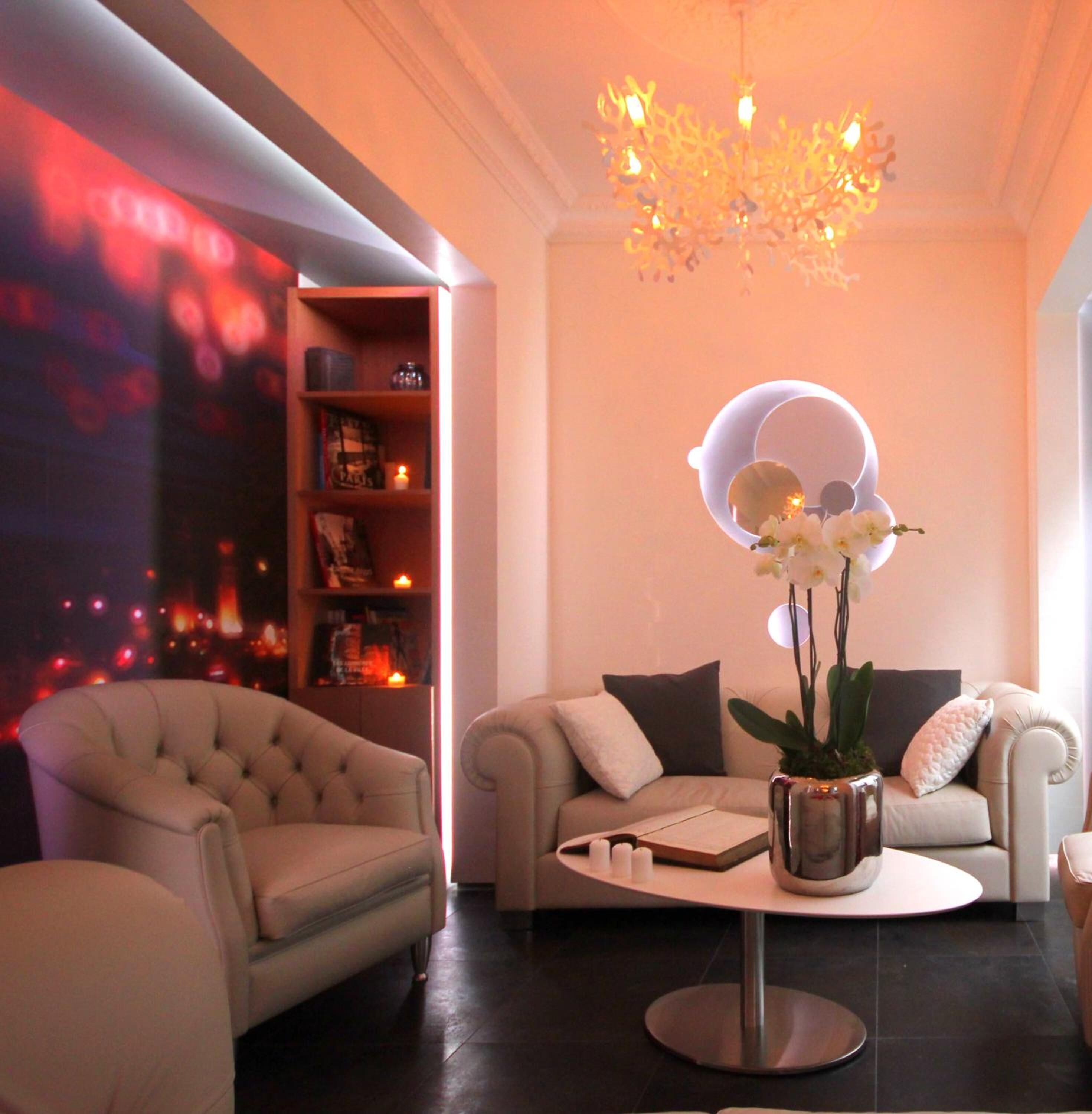 A modern living room with a round coffee table, two sofas, and a chandelier.