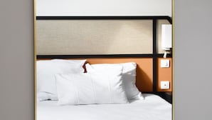 A hotel room with a bed, a headboard, a nightstand, and a mirror. - Hôtel Moderne (Arras)