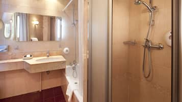 A modern bathroom with a sink, mirror, and shower.