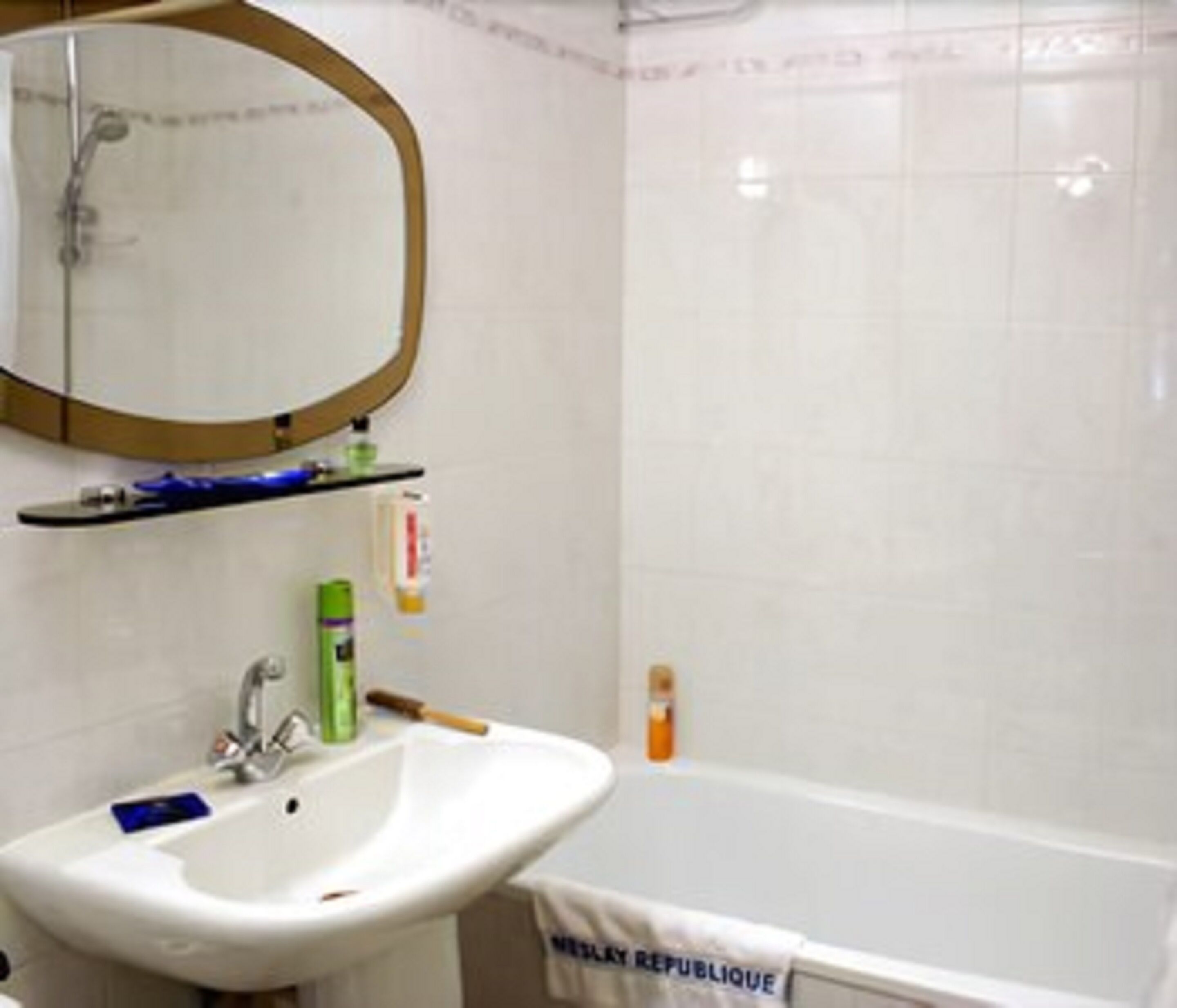 A bathroom with a white sink, a mirror, and a bathtub.