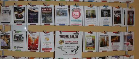 A wall of various travel and local business cards, including museums, restaurants, and services.