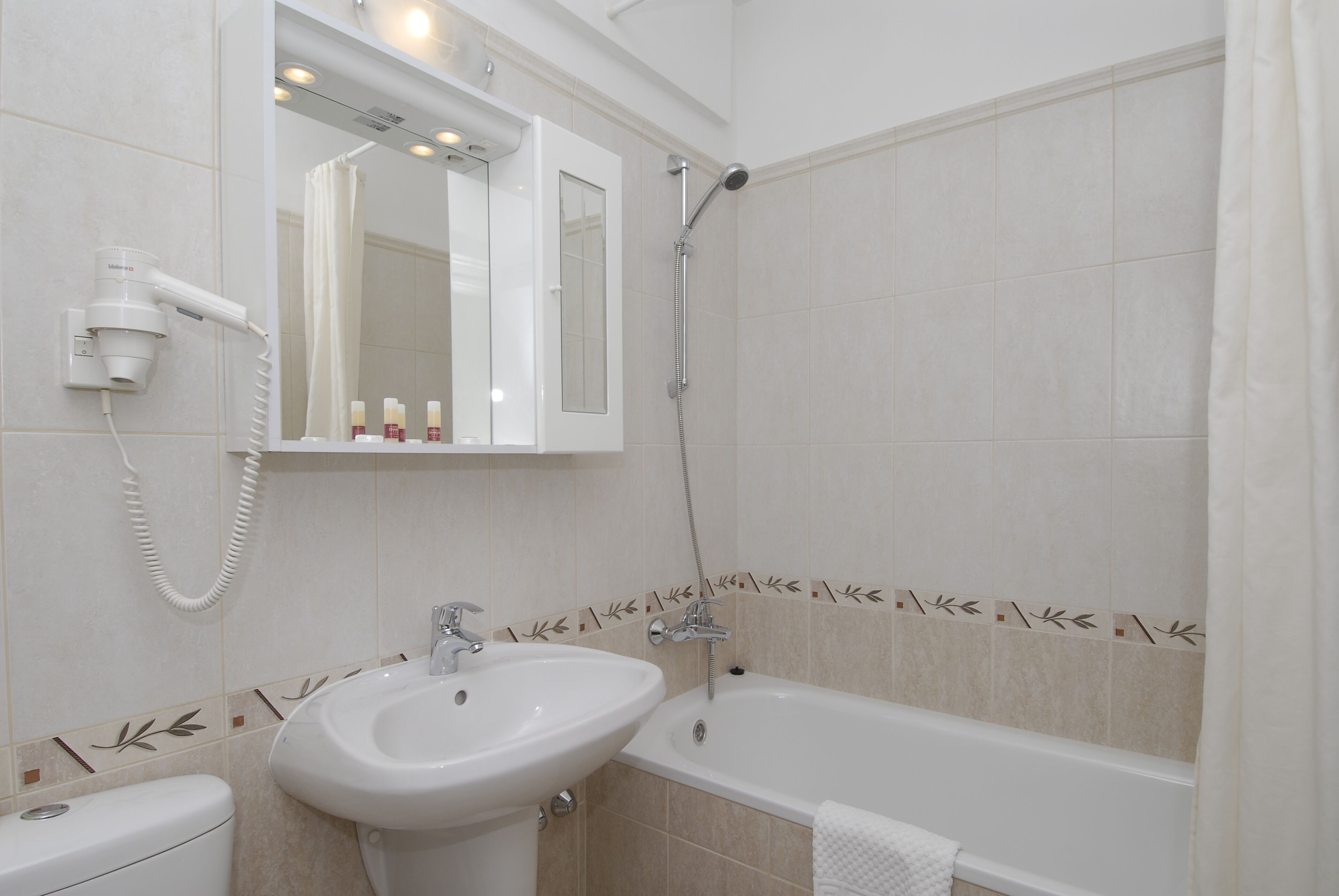 A bathroom with a white sink, a toilet, a bathtub, and a shower.