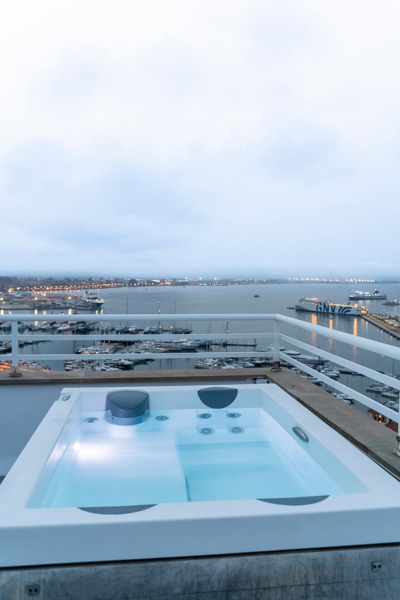 Un jacuzzi sur le toit offrant une vue sur une marina et des bateaux.