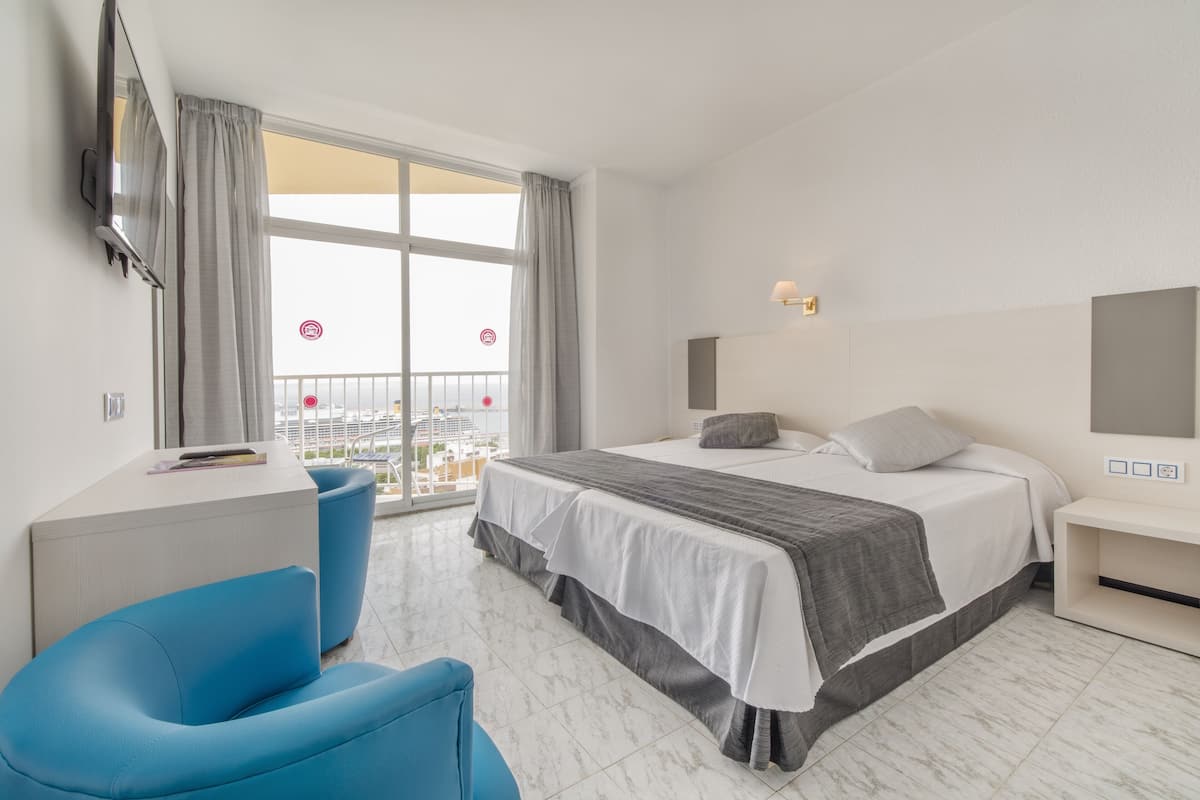 Une chambre d’hôtel moderne équipée d’un grand lit, d’un bureau, d’une chaise et d’un téléviseur.