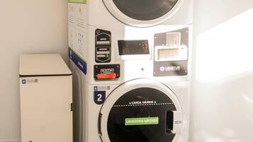 A laundry facility with a Secadora-Dryer and a Lavadora-Washer, marked as units 1 and 2 respectively, in a room with wooden flooring.