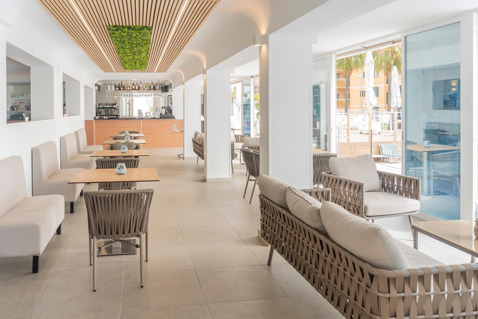 Een modern restaurant met een bar, zitplaatsen en uitzicht op het omliggende gebied.