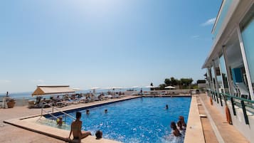 Una piscina al aire libre, tumbonas