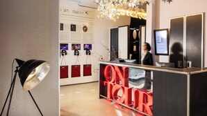 A reception area with a desk, a poster on the wall, and a ceiling with star decorations. - Hôtel du Triangle d'Or (Paris)