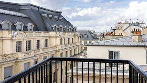 A multi-story building with classical architecture, featuring arched windows and a balcony railing. - Hôtel du Triangle d'Or (Paris)