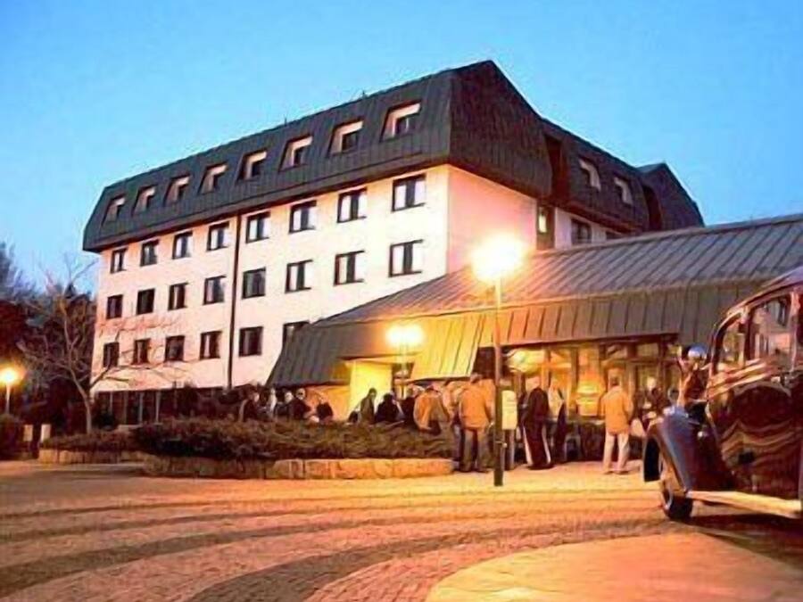 A multi-story hotel with a modern architectural design, featuring a flat roof and multiple windows.