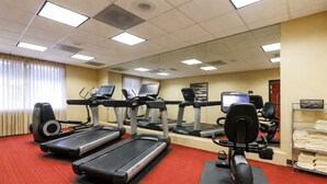 Un centre de remise en forme équipé de tapis de course, de vélos elliptiques et d’un vélo d’appartement.