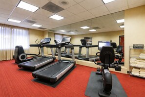 A fitness center with treadmills, elliptical machines, and a stationary bike. - BNA Suites (Nashville)