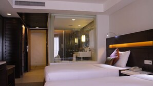 Una habitación de hotel con dos camas, un baño y un escritorio.