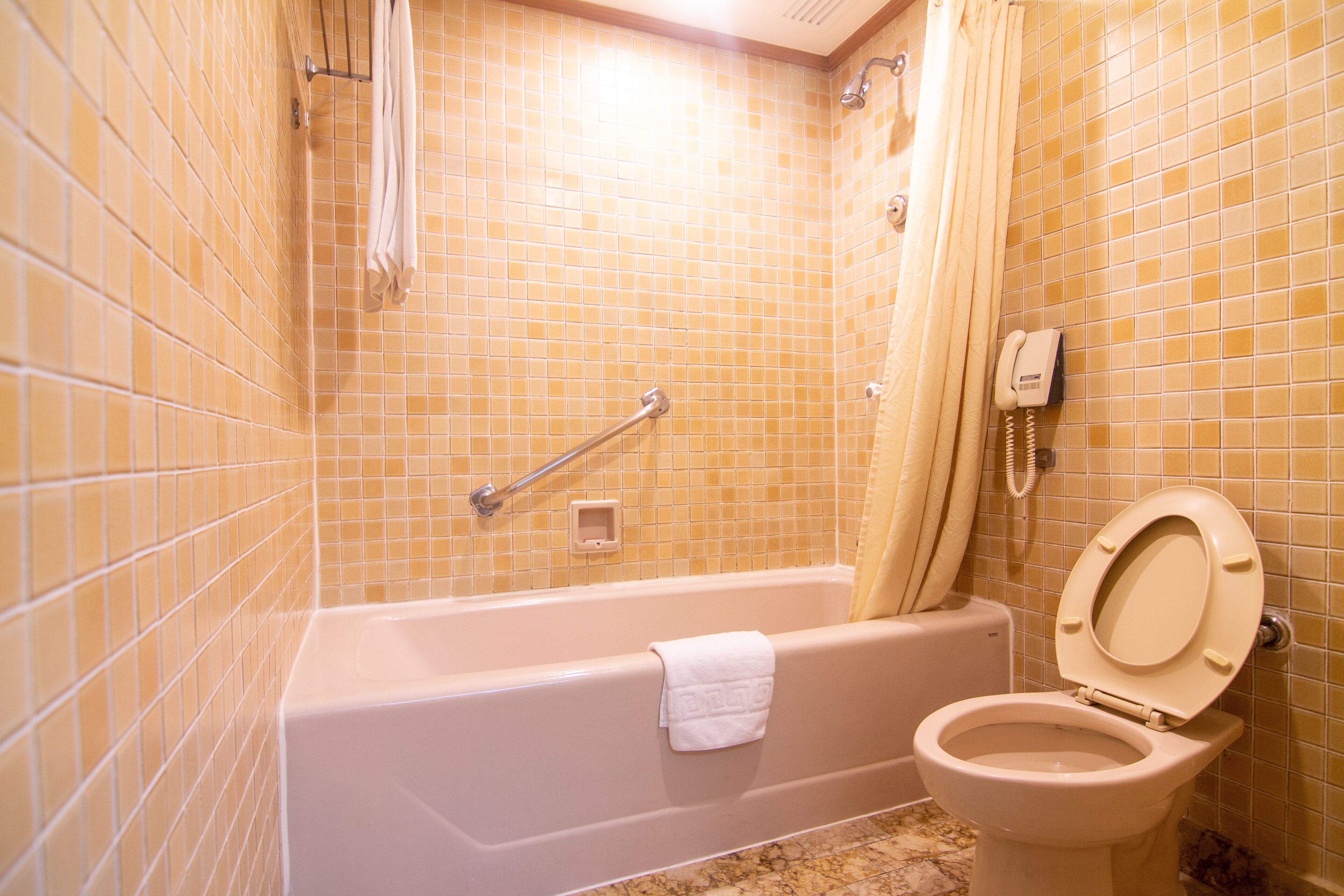 A bathroom with a bathtub, toilet, and a shower area.