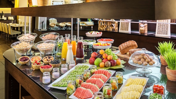 Een buffet met verschillende soorten fruit, groenten en drankjes.