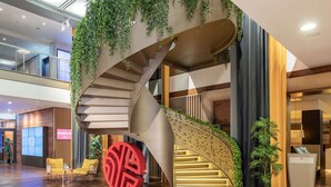 Een modern interieur met een spiltrap, houten vloer en binnenshuis planten.