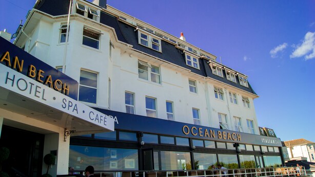 A multi-story building with signs for "Ocean Beach Hotel," "Spa," and "Cafe." - Ocean Beach Hotel and SPA Bournemouth - OCEANA COLLECTION (Bournemouth)