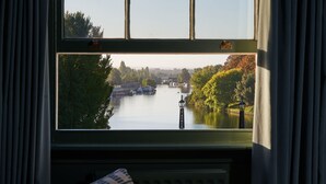 A view from a window with a view of a river, trees, and a lamp post. - The Mitre, Hampton Court (East Molesey)