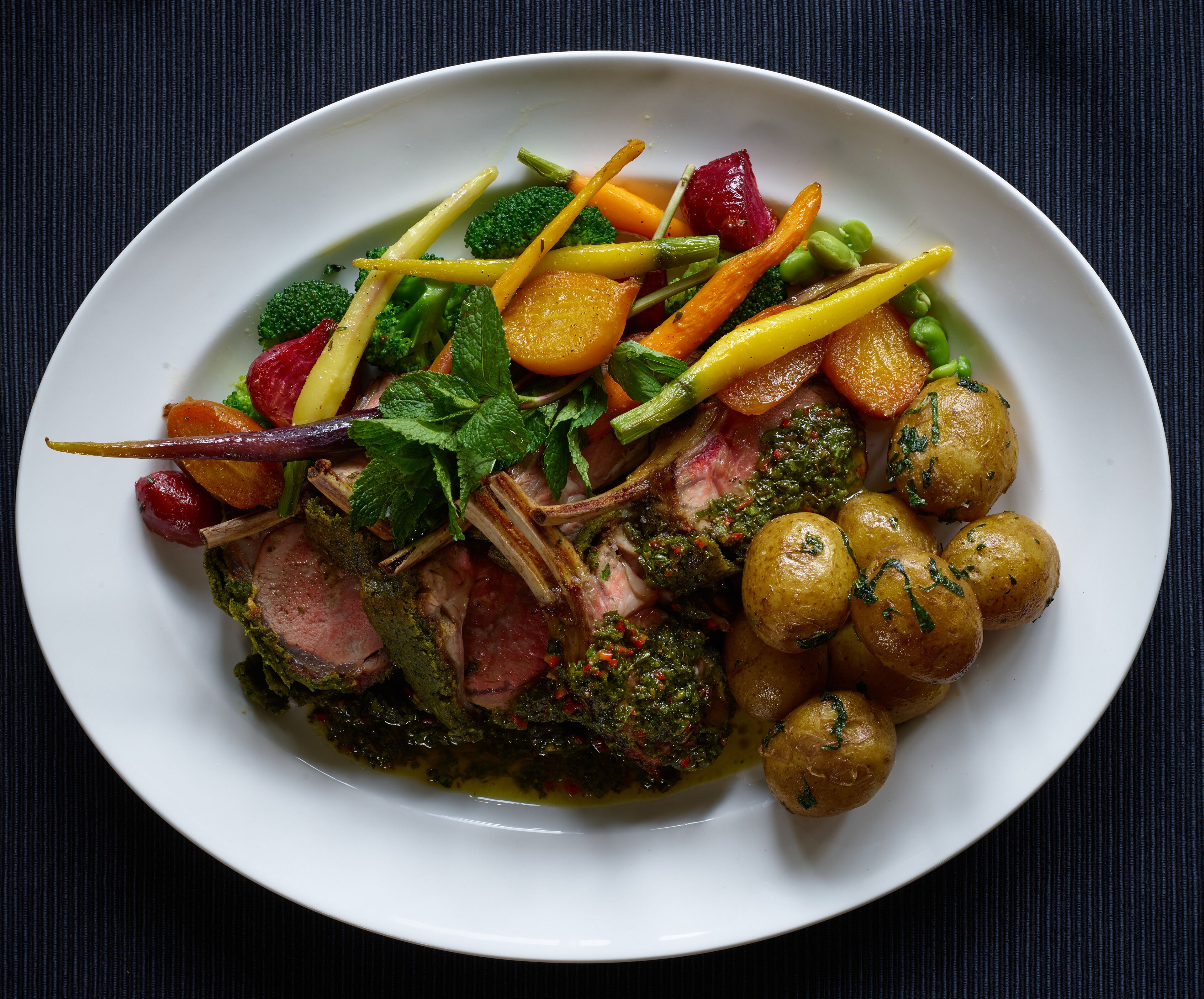 Un plato de comida con varias verduras y un trozo de carne.