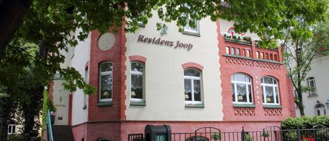 Un edificio de dos plantas con un letrero que dice "Residenz Joop HOTEL".