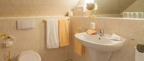 A bathroom with a toilet, sink, and towel rack.