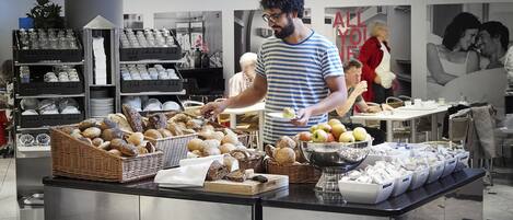 Zona de buffet con distintos alimentos y un encargado.