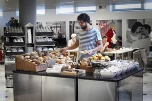 Een buffetruimte met diverse gerechten en een buffetmedewerker.