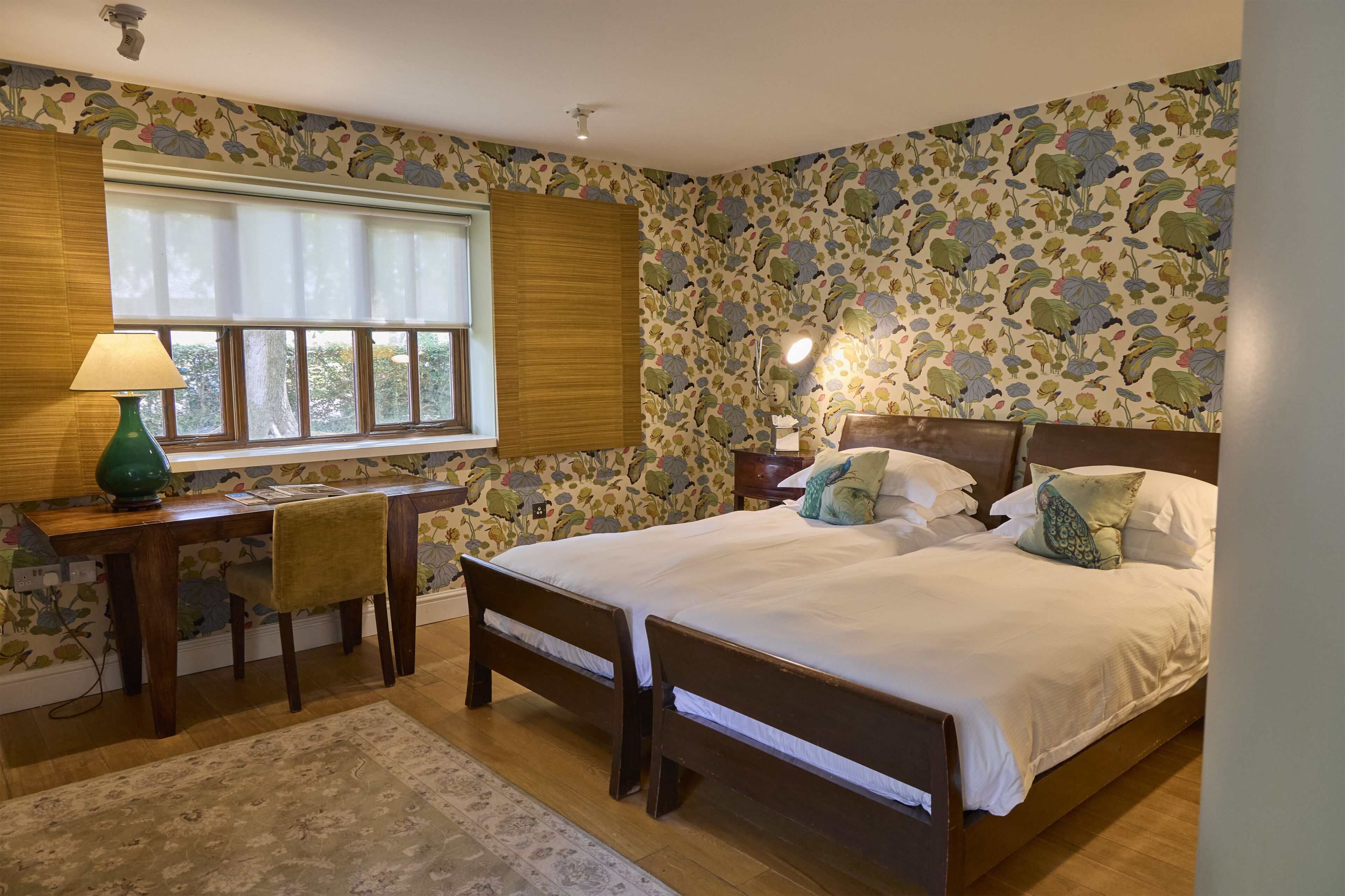 A bedroom with a wooden bed, a desk, and a chair.