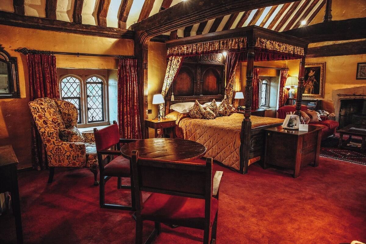 Une chambre de style traditionnel, avec un lit à baldaquin, une table en bois et une chaise.