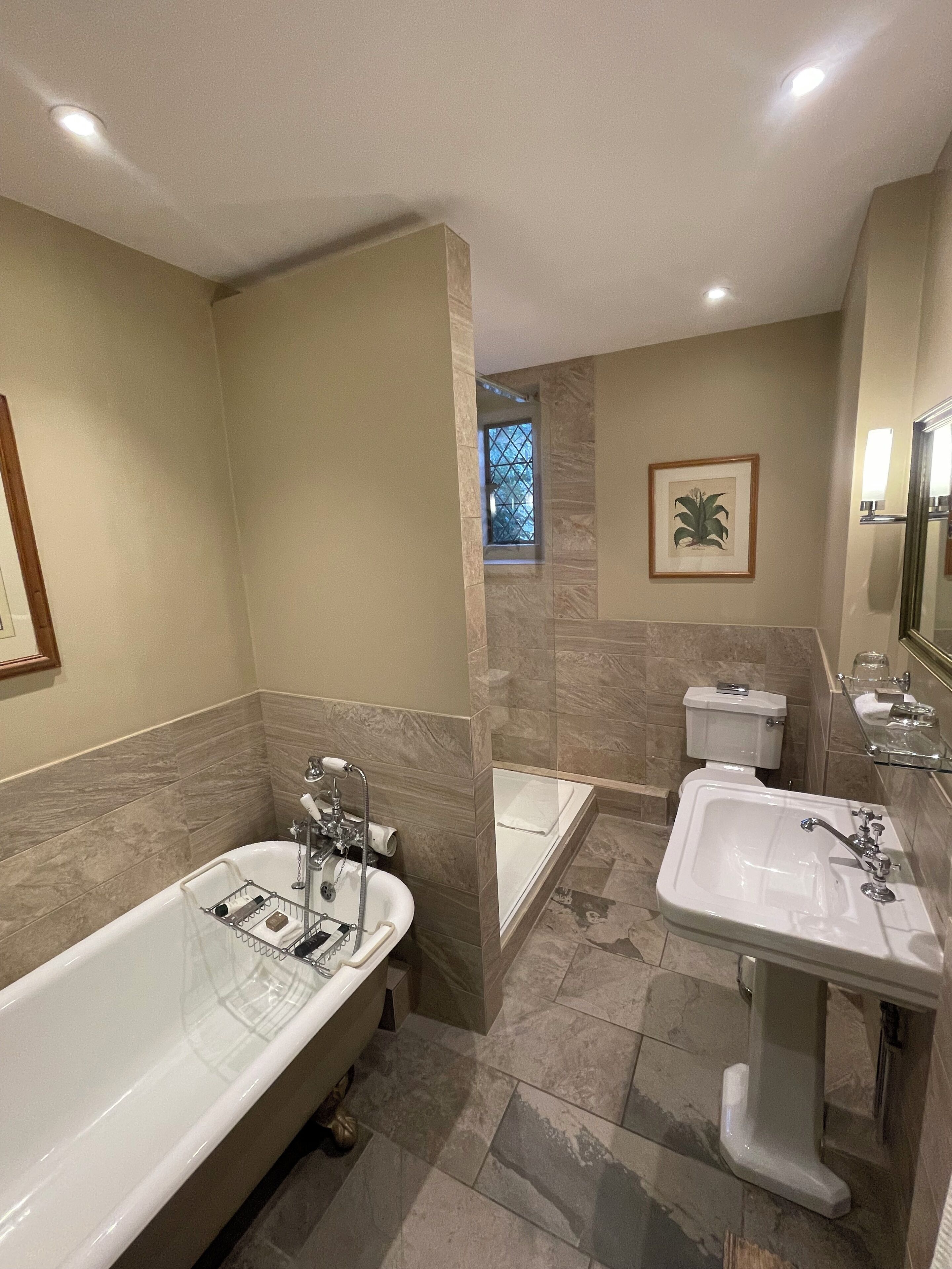 A bathroom with a bathtub, a separate shower area, and a sink.