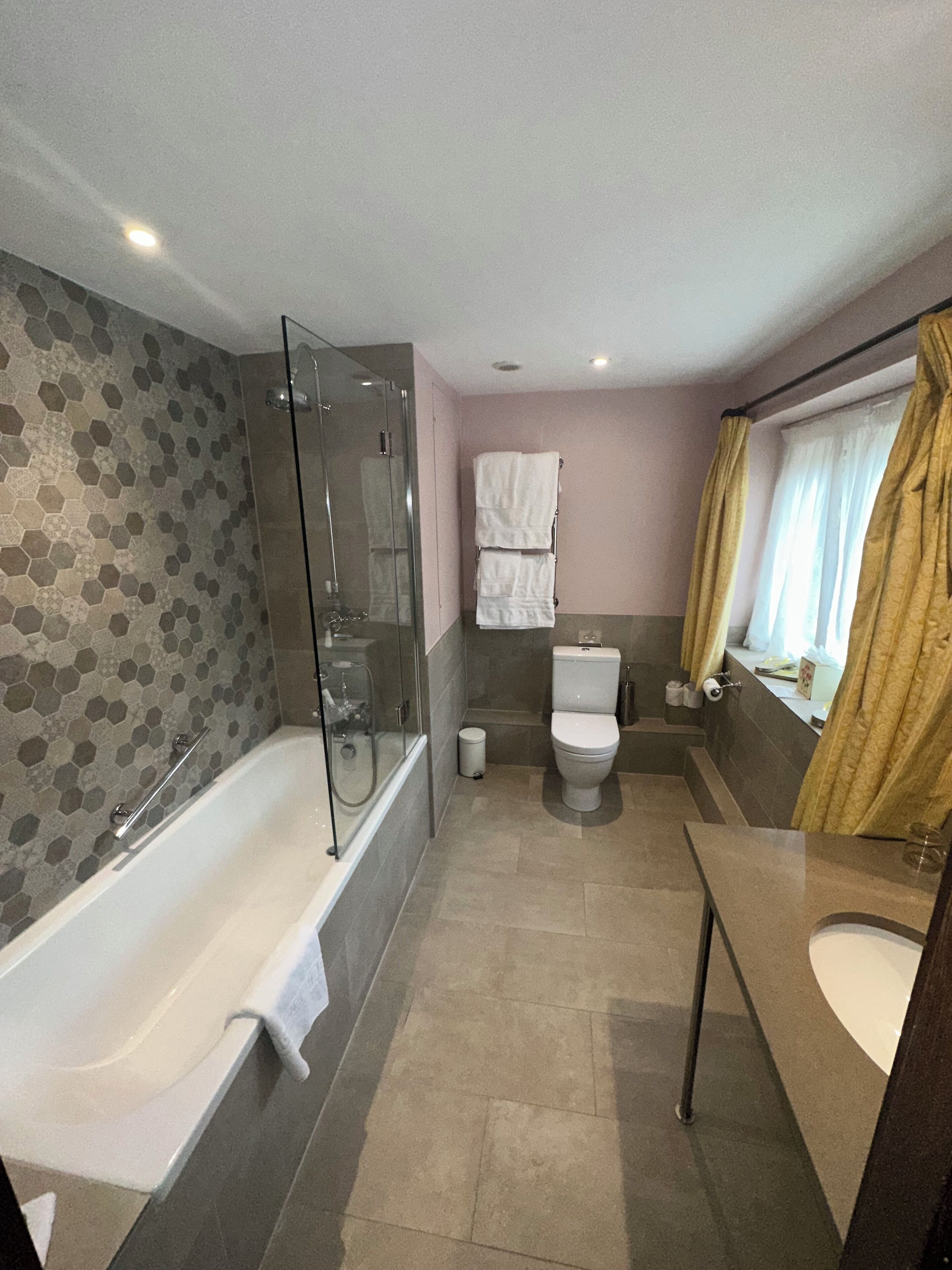 Un baño moderno con ducha envuelta en vidrio, inodoro y bañera.