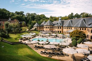 A large building with a swimming pool and outdoor seating area. - Pennyhill Park (Bagshot)