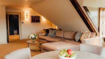 A modern living room with a sofa, coffee table, and a bowl of fruit.