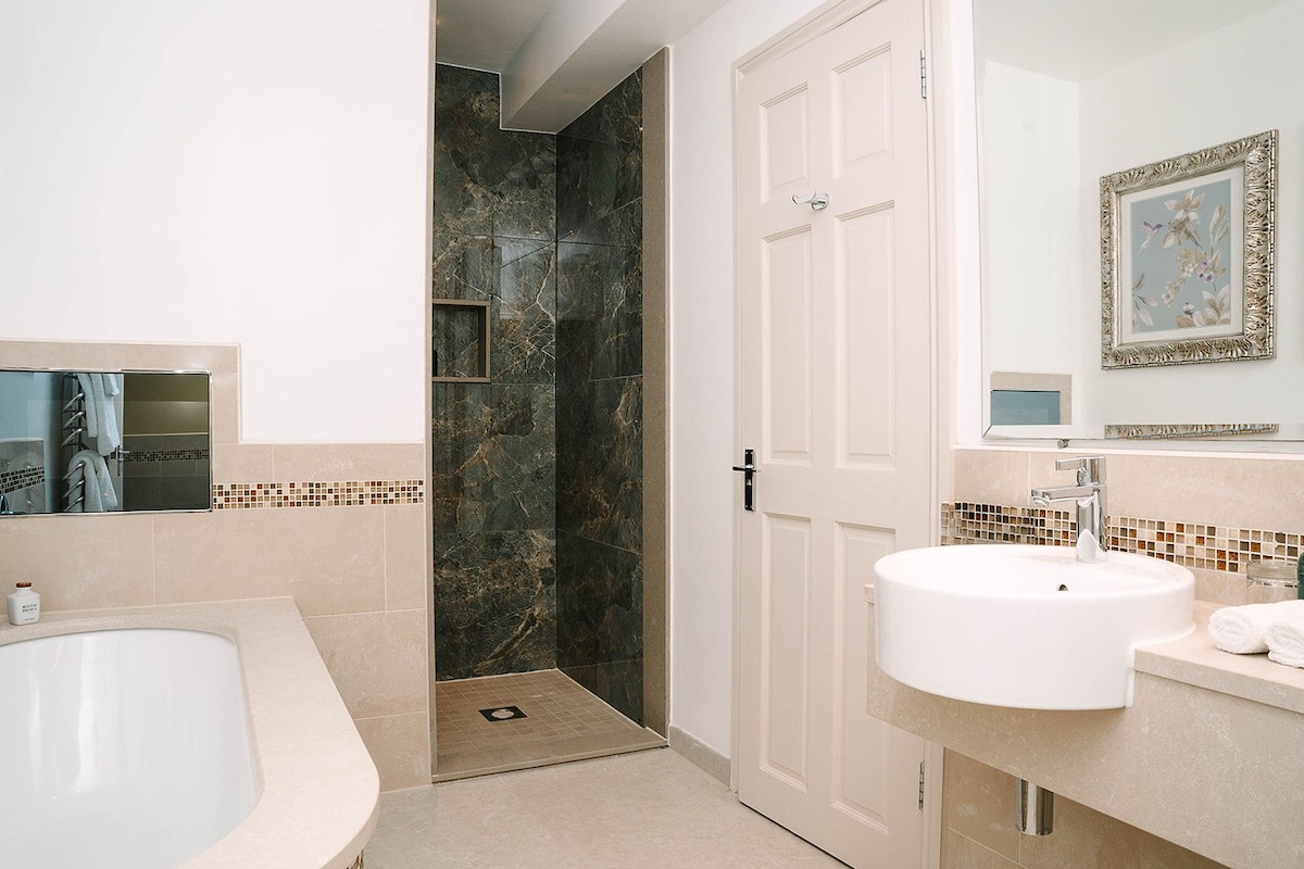 Un baño moderno con bañera, ducha y lavamanos.