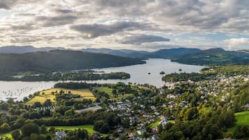 Vista panorámica de un pueblo a orillas del lago, con zonas residenciales, un puerto deportivo y colinas circundantes.