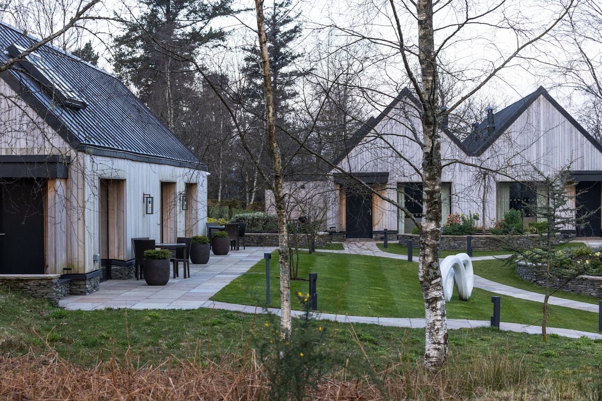 A modern building with a sloped roof, a paved pathway, and a well-maintained lawn.