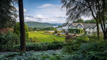 A large house with a well-maintained lawn and a view of a lake.