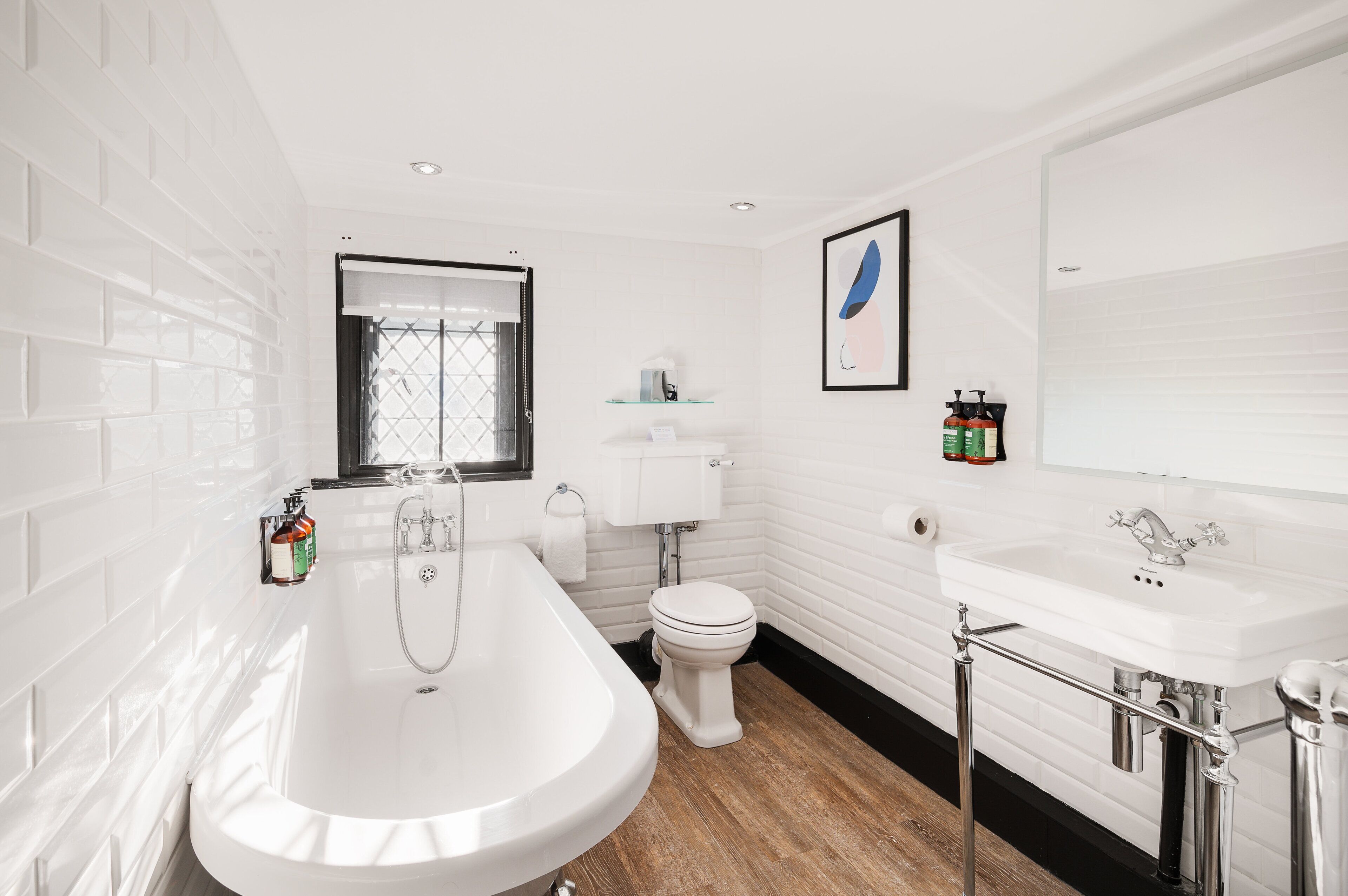 A modern bathroom with a freestanding bathtub, a toilet, and a sink.
