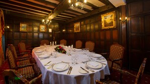 A dining room with a round table set for a meal, surrounded by patterned chairs. - Prince Rupert Hotel (Shrewsbury)