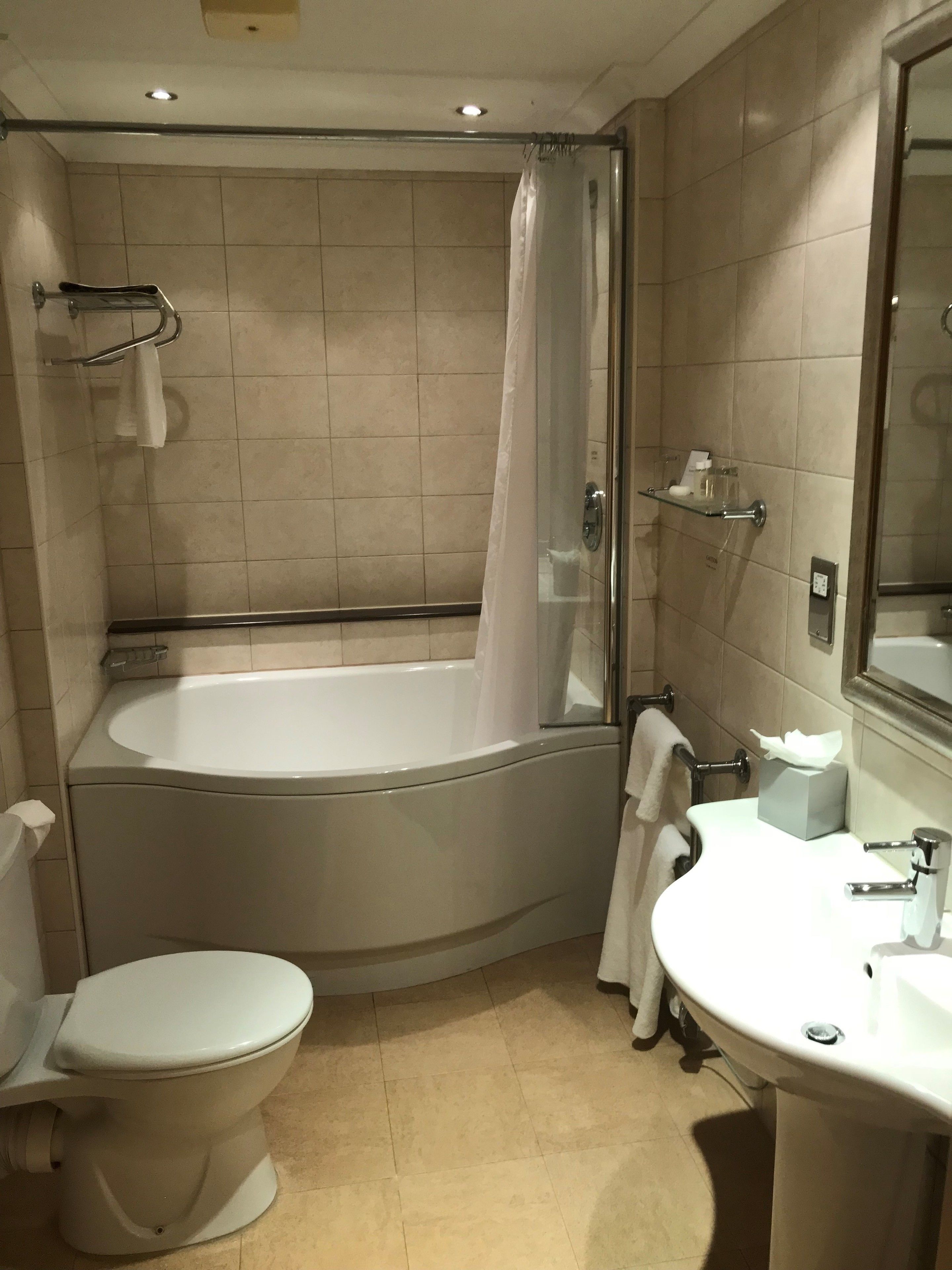 A bathroom with a bathtub, toilet, and sink.